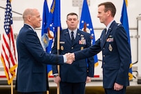 Men in uniform conduct a ceremony.