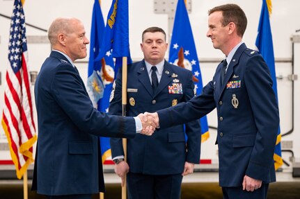 Men in uniform conduct a ceremony.