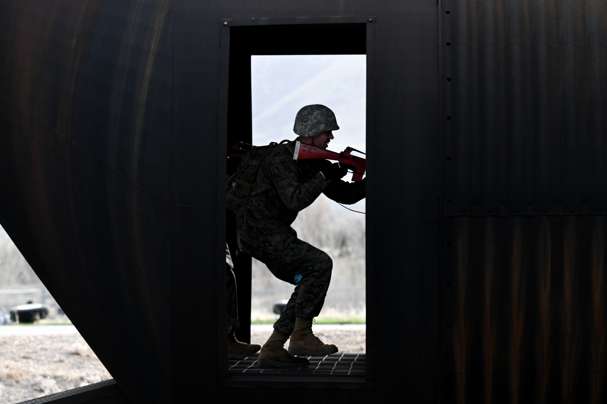 Silhouette of a ROTC student holding a weapon in a doorway