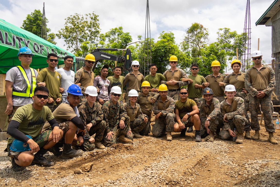 U.S. Marines with Marine Wing Support Squadron 174, Marine Aircraft Group 24, 1st Marine Aircraft Wing and Philippine Engineers with the 357th Air Engineering Squadron members pose for a team photo during Exercise Balikatan 25 at the Barangay Dagupan Multipurpose Gymnasium, Lal-lo, Cagayan, Philippines, April 8, 2025. Balikatan is a longstanding annual exercise between the Armed Forces of the Philippines and the U.S. military designed to strengthen our ironclad alliance, improve our capable combined force and demonstrate our commitment to regional security and stability (U.S. Marine Corps photo by Lance Cpl. Roger- Junior Annoh)