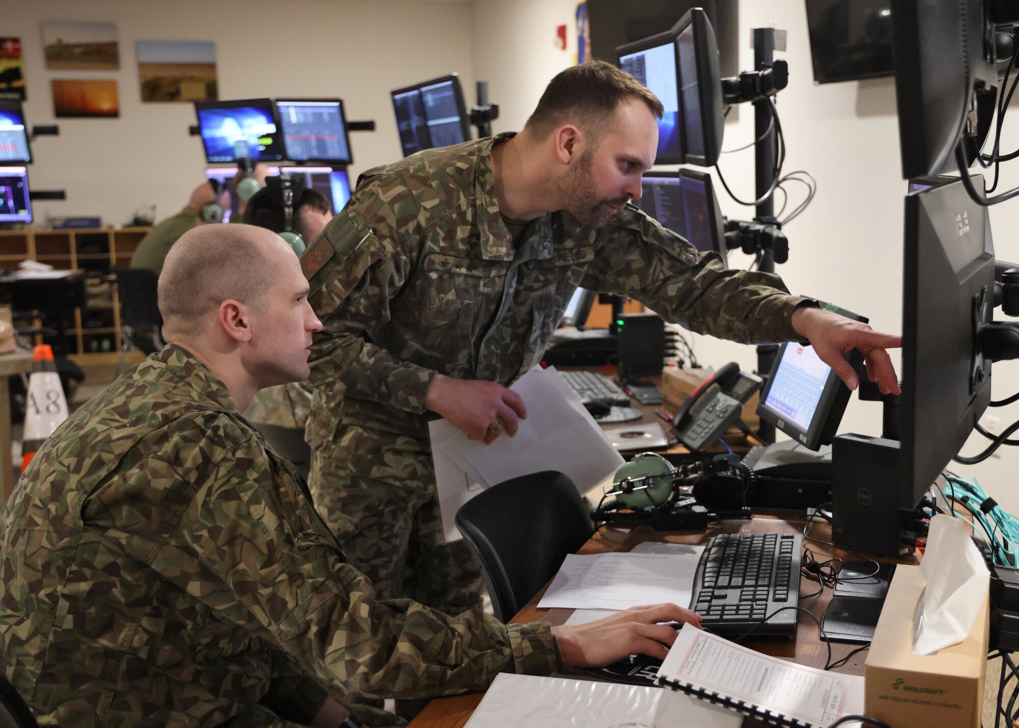 Capt. Aivis Kusins, left, and Capt. Kaspars Uspelis, fighter controllers with the Latvian Air Force, prepare for a mission debrief March, 31, 2025, during an exercise conducted with U.S. and NATO crewmembers at Volk Field Air National Guard Base in Camp Douglas, Wisconsin.