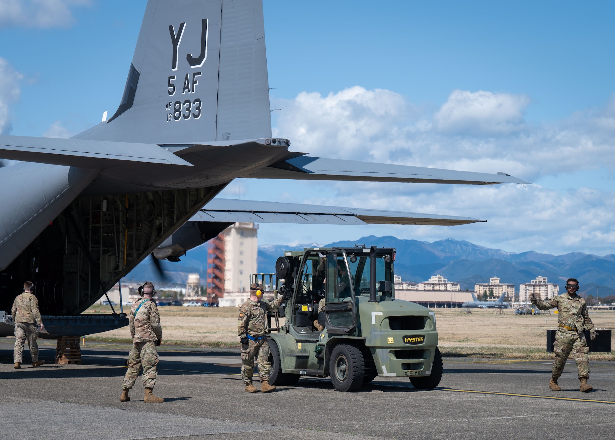 man in forklift loads c130j