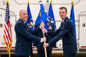 Men in uniform conduct a ceremony.