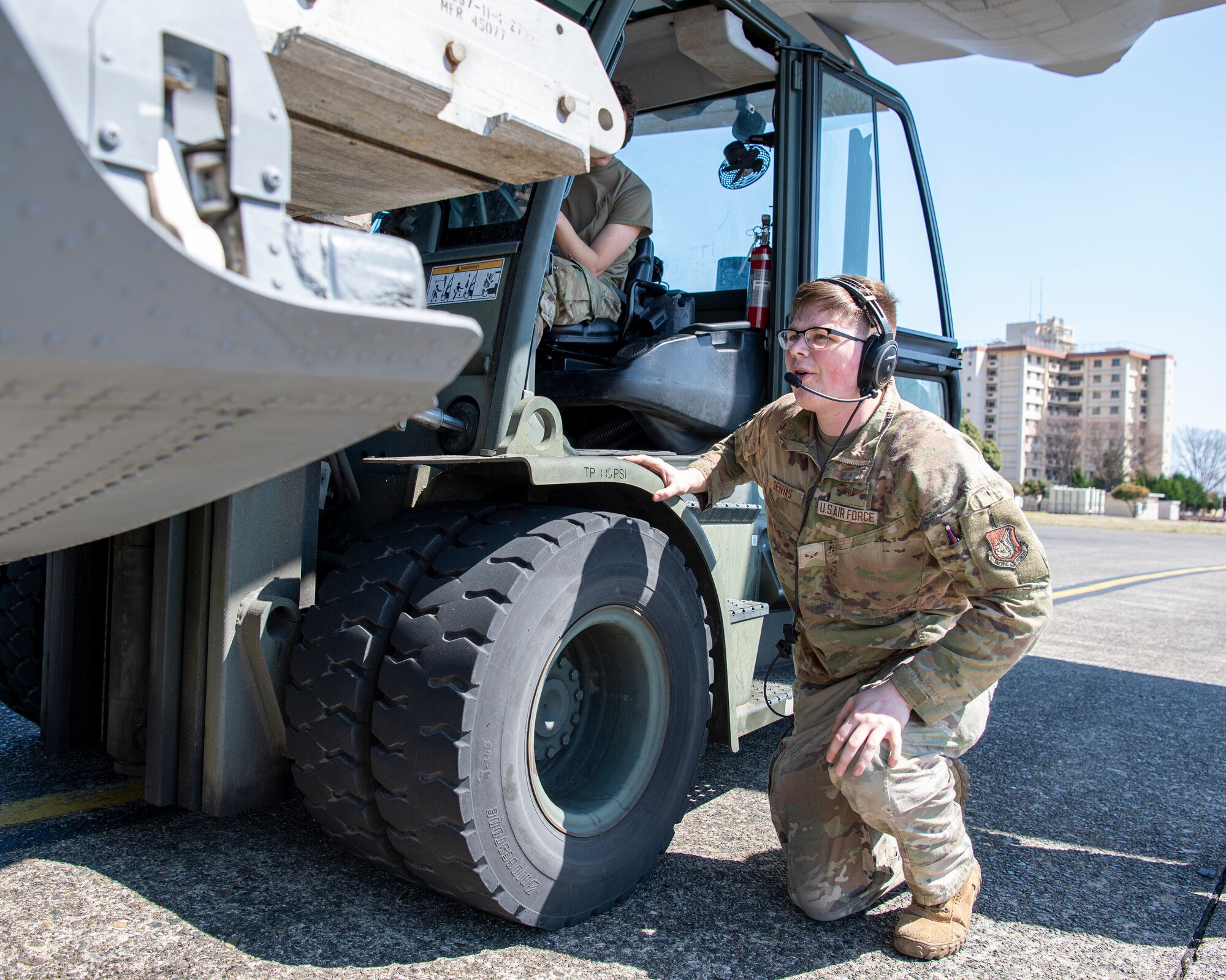 Airmen guides cargo forklift.