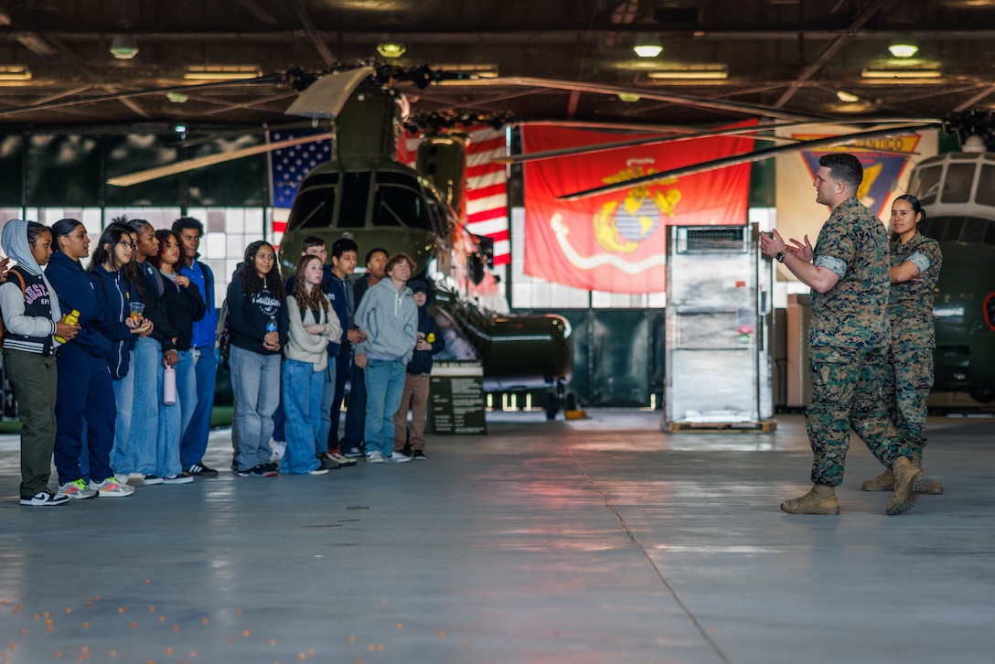 U.S. Marine Corps Sgt. John Cataldo, a military working dog handler with Marine Corps Air Facility Quantico, gives a military working dog handling brief to cadets from Brooke Point High School and Highland High School Navy Junior Reserve Officer Training Corps at MCAF on Marine Corps Base Quantico, Virginia, April 9, 2025. Cadets receive demonstrations on basic operations and procedures at MCAF Quantico, including expeditionary fire and emergency service, air control towers, military working dogs, and flight operations. (U.S. Marine Corps photo by Lance Cpl. Braydon Rogers)