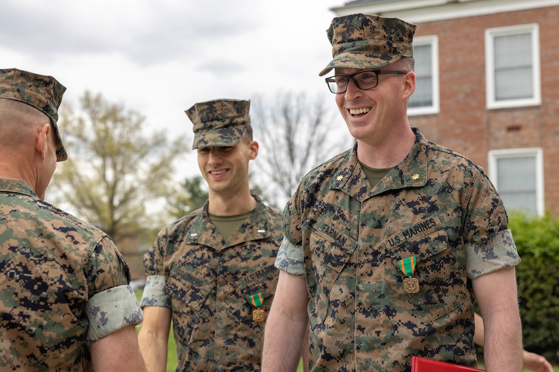 U.S. Marine Corps First Lt. Max Goldberg, left, and Maj. Michael Farnan, both defense council judge advocates for the National Capital Region at Marine Corps Base Quantico, are congratulated by the audience in attendance after being awarded a Navy and Marine Corps Achievement Medal on MCB Quantico, April 10, 2025. Goldberg and Farnan performed life-saving actions to an unconscious woman at a bus stop in Phoenix, Feb. 7 2025. Farnan immediately called emergency medical services while Goldberg looked for an opioid antagonist after realizing her pulse was low and breathing was shallow. After applying the Narcan, the woman’s condition improved, and emergency medical services arrived. As EMS took the woman, they explained to the Marines they probably saved her life. (U.S. Marine Corps photo by Lance Cpl. Harleigh Faulk)