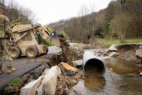 U.S. Army Sgt. Brian Mccall uses a skid steer to repair roadsides on a county road in Hindman, Ky. on April 1, 2025.