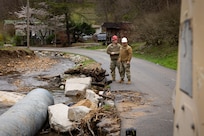 U.S. Army Spc. Devon Middleton and Sgt. Brian Mccall surveys flood damage on a county road in Hindman, Ky. on April 1, 2025.