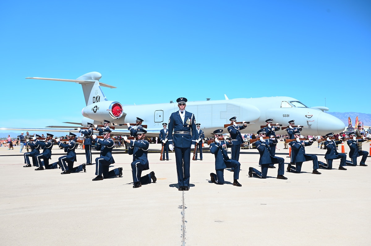 Members of the U.S. Air Force Honor Guard Drill Team pose with an EA-37B Compass Call after completing their performance at Davis-Monthan Air Force Base, Ariz., March 22, 2025. The elite team supports the Air Force Recruiting Service by serving as the official ambassadors in blue, showcasing precision, discipline and professionalism. The EA-37B is a specialized electronic warfare aircraft designed to disrupt enemy command and control communications, providing critical support to joint and allied operations. (U.S. Air Force photo by Senior Airman Andrew Garavito)