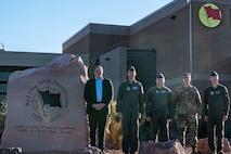 five men standing in front of a building
