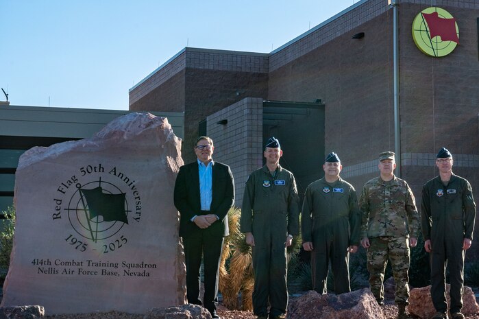 five men standing in front of a building