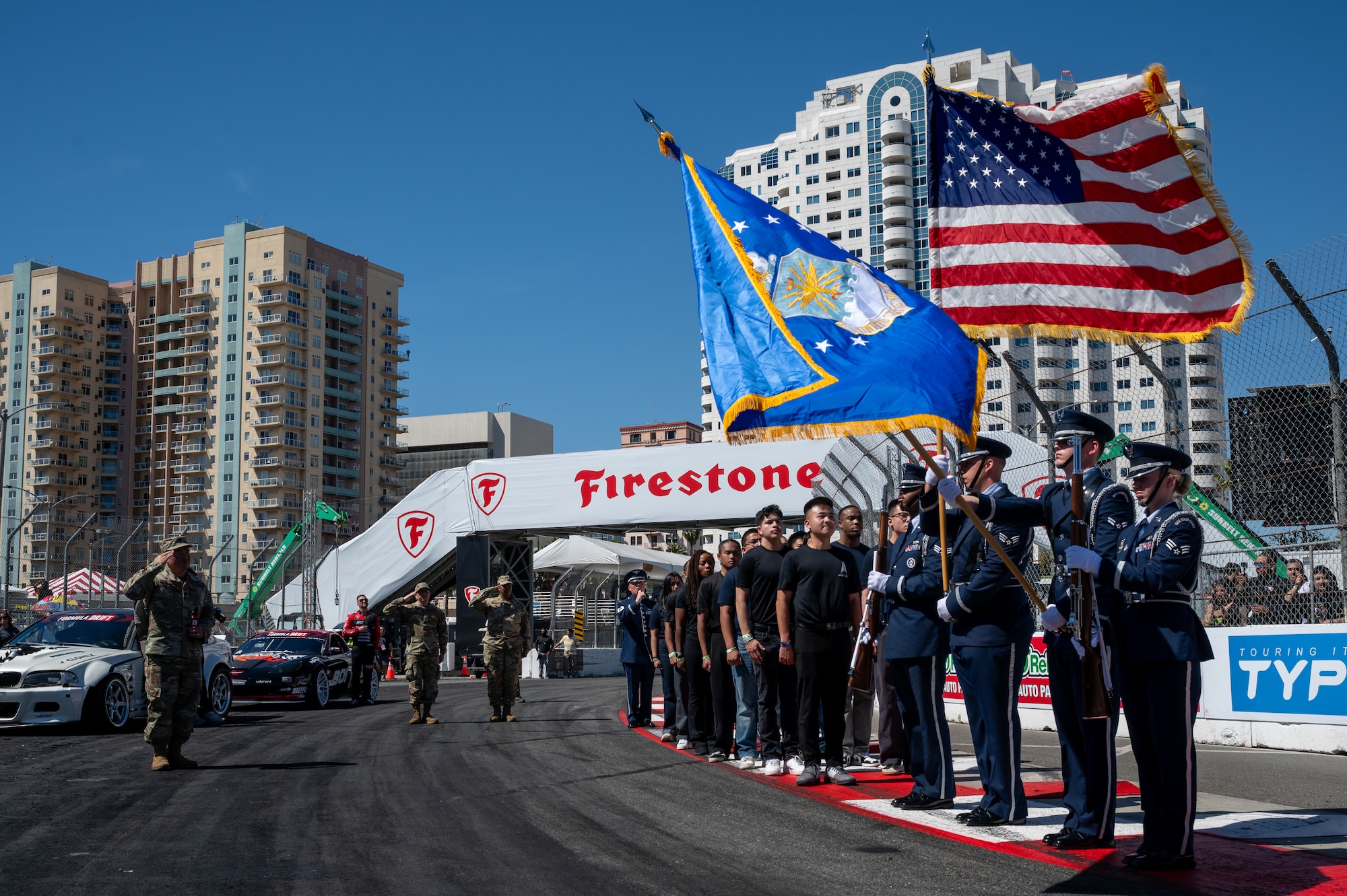 U.S. Air Force Tech. Sgt. Benton Felty, a vocalist with The U.S. Air Force Band’s Max Impact, sings “The Star-Spangled Banner” while the Edwards Air Force Base Honor Guard presents the colors and delayed entry program recruits stand at attention during a Formula Drift event, Long Beach, Calif., April 5, 2025. Max Impact partnered with Air Force Recruiting Service to perform and sing the national anthem at the event. Max Impact consists of six active-duty musicians stationed at Joint Base Anacostia-Bolling, Washington, D.C. (U.S. Air Force photo by Hayden Hallman)