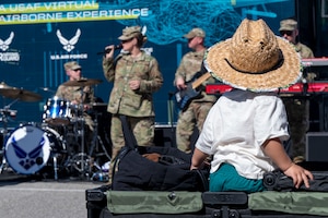 A child watches members of The U.S. Air Force Band’s Max Impact perform during the Southern California tour at a Formula Drift event, Long Beach, Calif., April 5, 2025. The mission of Max Impact, a rock band, is to honor those who have served, inspire American citizens to heightened patriotism and service, and connect the global community on behalf of the Air Force and the United States. Max Impact consists of six active-duty musicians stationed at Joint Base Anacostia-Bolling, Washington, D.C. (U.S. Air Force photo by Hayden Hallman)