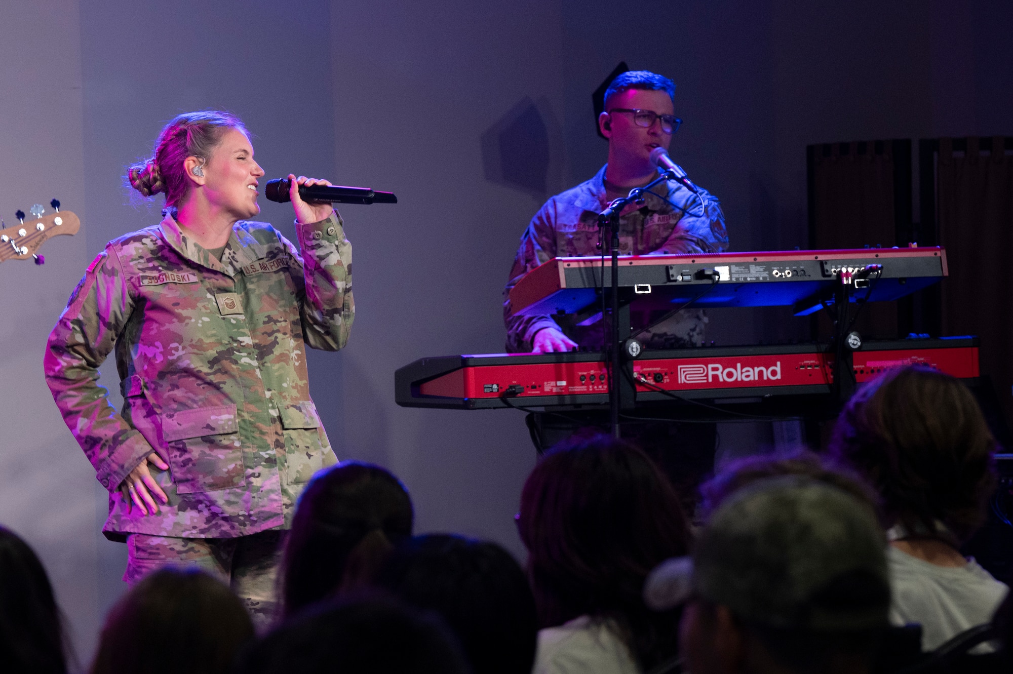 From left, U.S. Air Force Master Sgt. Nadia Sosnoski, the noncommissioned officer in charge of flight operations and a vocalist, and Tech. Sgt. Aaron Trasatt, keyboardist, both with The U.S. Air Force Band's Max Impact, perform to an audience of students during the Max Impact Southern California tour at Orange County School of the Arts, Santa Ana, Calif., April 7, 2025. The mission of Max Impact, a rock band, is to honor those who have served, inspire American citizens to heightened patriotism and service, and connect the global community on behalf of the Air Force and the United States. Max Impact consists of six active-duty musicians stationed at Joint Base Anacostia-Bolling, Washington, D.C. (U.S. Air Force photo by Hayden Hallman)