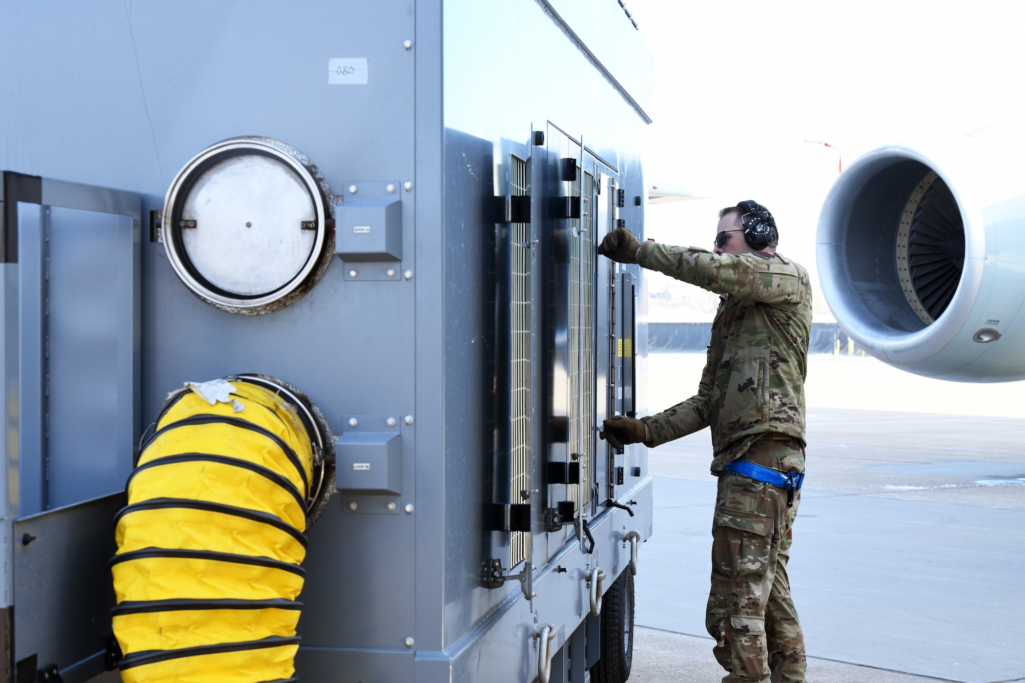 Airman turns on 808 air conditioning cart during preflight checks.
