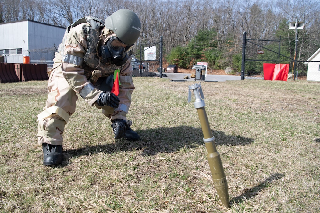 Image of an Airman marking around an unexploded ordinance.