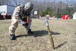 Image of an Airman marking around an unexploded ordinance.