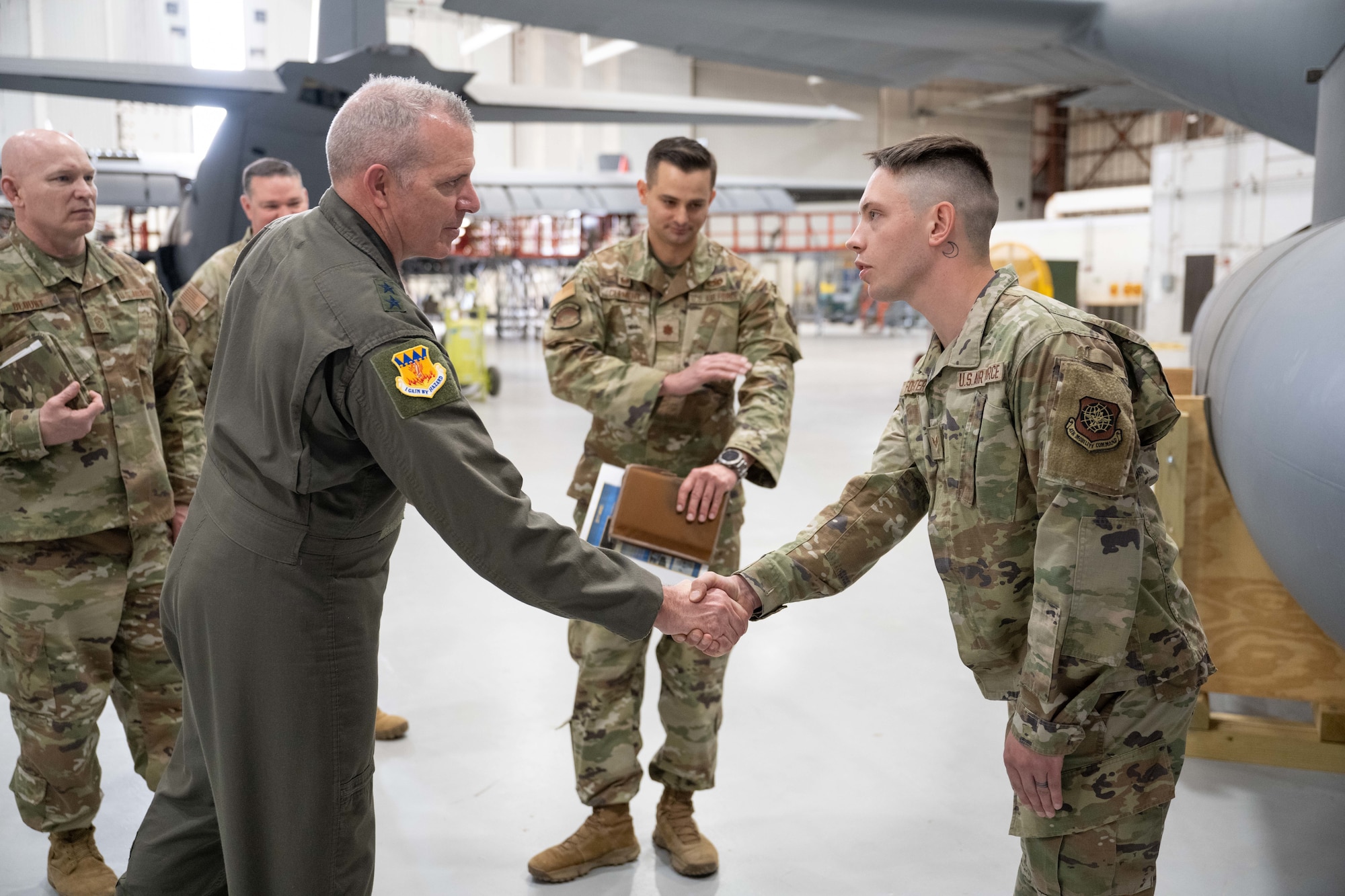 U.S. Air Force Maj. Gen. Charles Bolton, 18th Air Force commander, coins Senior Airman Christian Foster, 317th Maintenance Squadron aircraft fuels systems journeyman, during an immersion at Dyess Air Force Base, Texas, April 2, 2025. The 18th AF command team took the opportunity to recognize superior performers for their contributions to generate and employ tactical combat airlift. (U.S. Air Force photo by Airman Caleb Schellenberg)