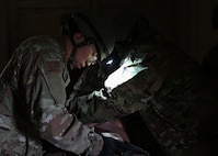 Airman practicing life-saving care on a mannequin.