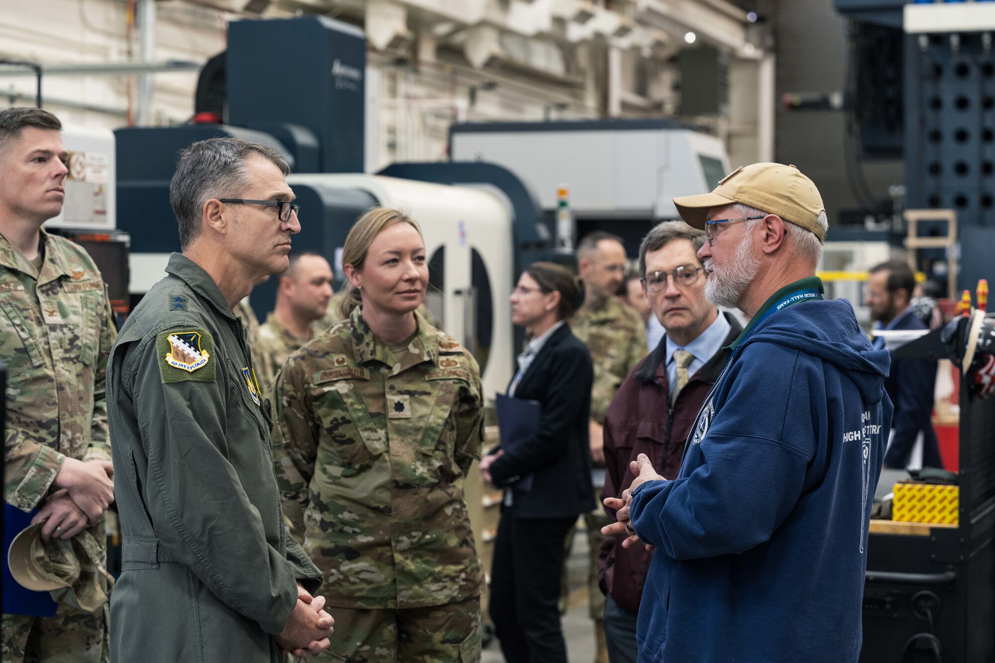 U.S. Air Force Maj. Gen. Scott Cain, Air Force Test Center commander, second left, hears about machining processes from Ziggy Pieszala, 846th Test Squadron model maker supervisor, at Holloman Air Force Base, New Mexico, March 21, 2025. Pieszala discussed various equipment used in daily work and suggestions for upgrades. (U.S. Air Force photo by Airman 1st Class Bob Teichmann)