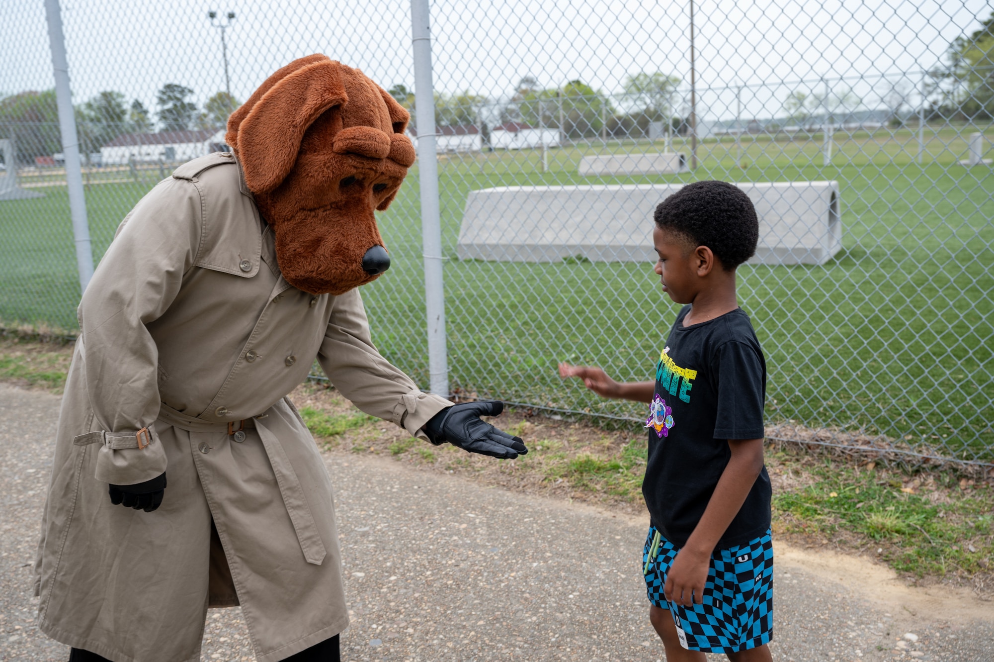 Child high fives dog mascot. (U.S. Air Force Photo by Airman 1st Class Donnell Ramsey)