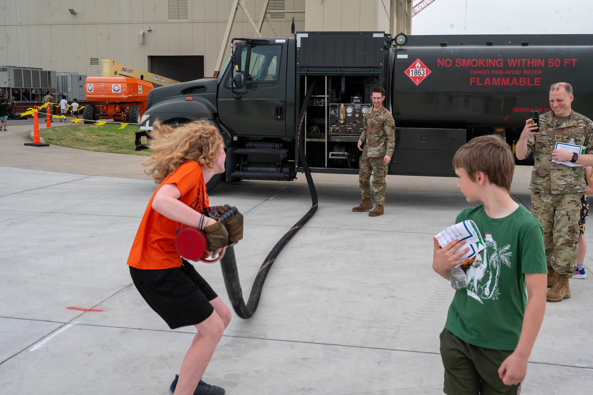 Child pulls a hose from a fuel truck. (U.S. Air Force Photo by Airman 1st Class Donnell Ramsey)