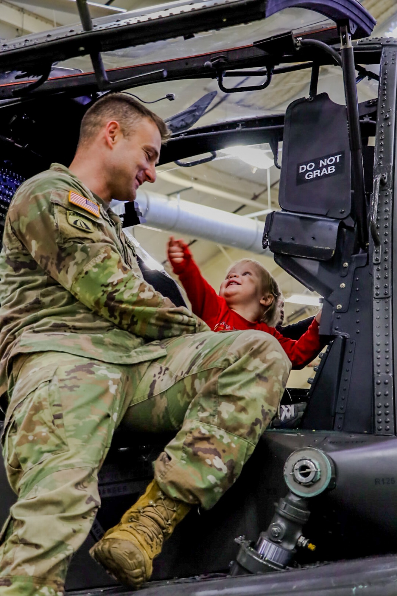 Soldier holds child in helicopter seat. (Courtesy Photo)