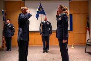U.S. Air Force Col. Michael S. Lineberger, 145th Operations Group commander, left, and Lt. Col. Erin M. Root, 235th Combat Airfield Operations Squadron (235 CAOS) commander, right, render salutes at the 235 CAOS redesignation ceremony at the North Carolina Air National Guard’s New London, N.C. location, March 7, 2025.