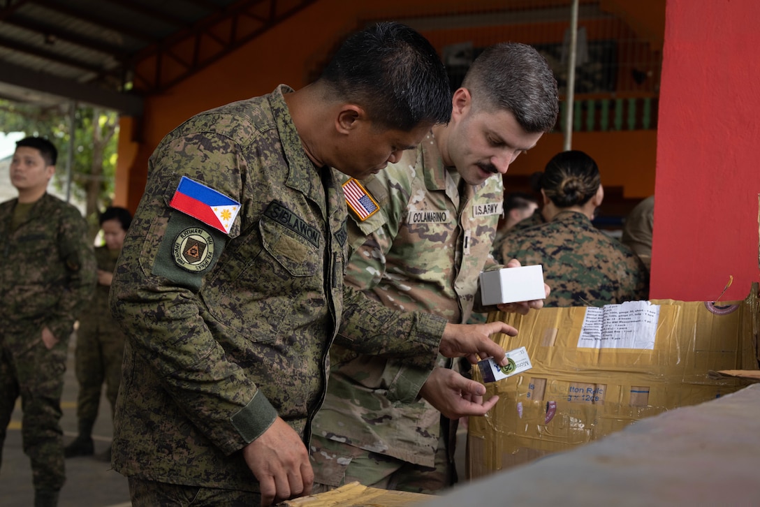 U.S. Army Capt. Aaron Colamarino, right, a periodontist with the Combined Joint Civil-Military Operations Task Force, and an Armed Forces of the Philippines member inspect dental supplies during Exercise Balikatan 25 at the Barangay Dagupan Multipurpose Gymnasium, Lal-lo, Cagayan, Philippines, April 8, 2025. Balikatan is a longstanding annual exercise between the Armed Forces of the Philippines and the U.S. military designed to strengthen our ironclad alliance, improve our capable combined force and demonstrate our commitment to regional security and stability (U.S. Marine Corps photo by Lance Cpl. Roger- Junior Annoh)