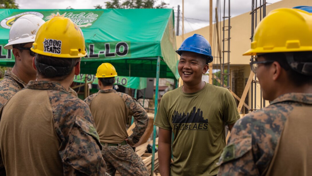 Philipine Air Force A2C Melvin Mendoza, an engineer with the 357th Air Engineering Squadron, laughs alongside U.S. Marine Corps combat engineers assigned to Marine Wing Support Squadron 174, Marine Aircraft Group 24, 1st Marine Aircraft Wing, at a construction site during Exercise Balikatan 25 at the Barangay Dagupan Multipurpose Gymnasium, Lal-lo, Cagayan, Philippines, April 8, 2025. Balikatan is a longstanding annual exercise between the Armed Forces of the Philippines and the U.S. military designed to strengthen our ironclad alliance, improve our capable combined force and demonstrate our commitment to regional security and stability (U.S. Marine Corps photo by Lance Cpl. Roger- Junior Annoh)