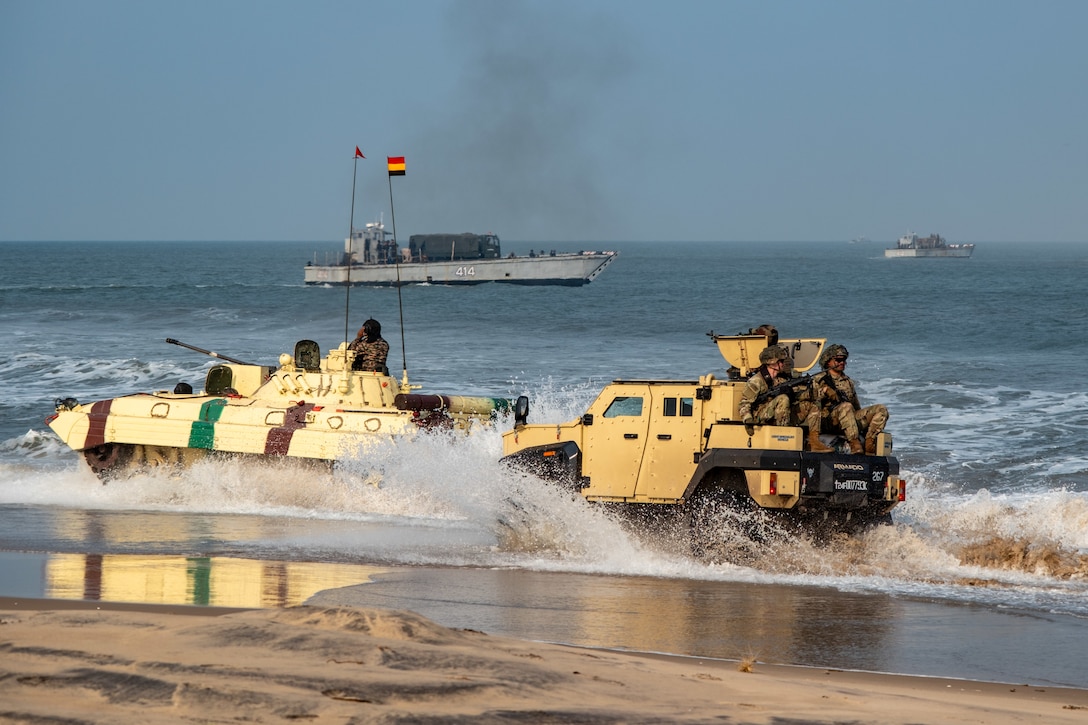 KAKINADA, Andhra Pradesh, India (April 11, 2025) - Indian Army (IA) personnel from the 4/8 Gurkha Rifles Infantry Battalion, 91st Infantry Brigade, traverse the beach in an IA BMP-II Sarath amphibious infantry combat vehicle, left, with an IA Mahindra Armored Light Specialist Vehicle, along with two U.S. Army 11th Airborne Division personnel, while two landing craft mechanized (LCM-8), launched from Indian Navy amphibious transport dock INS Jalashwa (L41), pull away during a large-scale amphibious landing drill held as part of Exercise Tiger Triumph 2025, at Kakinada Beach, Andhra Pradesh, India, April 11. Tiger Triumph is a joint and combined U.S.-India exercise focused on humanitarian assistance and disaster response readiness and interoperability. Tiger Triumph enables U.S. and Indian armed forces to improve interoperability and bilateral, joint, and service readiness in the Indian Ocean region and beyond to support a free and open Indo-Pacific. (U.S. Navy photo by Mass Communication Specialist 1st Class Caroline H. Lui)