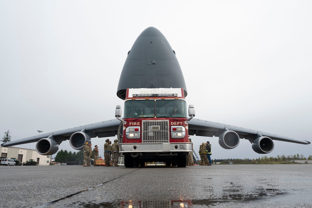 U.S. Air Force Airmen with the 62d Aerial Port Squadron, 446th APS and 709th Airlift Squadron from Dover Air Force Base, Delaware, load a fire truck onto a C-5M Super Galaxy at Joint Base Lewis-McChord, Washington, April 8, 2025. 
A donated fire truck arrived at JBLM via flatbed truck to be shipped to Guatemala in support of the Denton Humanitarian Assistance Program.