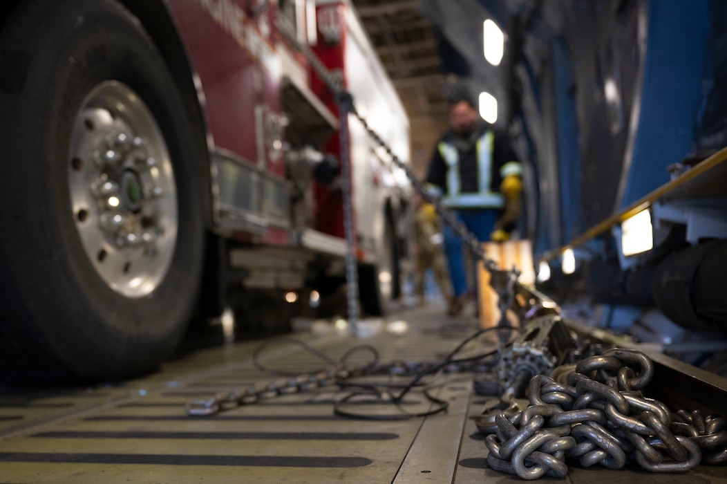 U.S. Air Force Airmen with the 62d Aerial Port Squadron, 446th APS and 709th Airlift Squadron from Dover Air Force Base, Delaware, load a fire truck onto a C-5M Super Galaxy at Joint Base Lewis-McChord, Washington, April 8, 2025. 
A donated fire truck arrived at JBLM via flatbed truck to be shipped to Guatemala in support of the Denton Humanitarian Assistance Program.