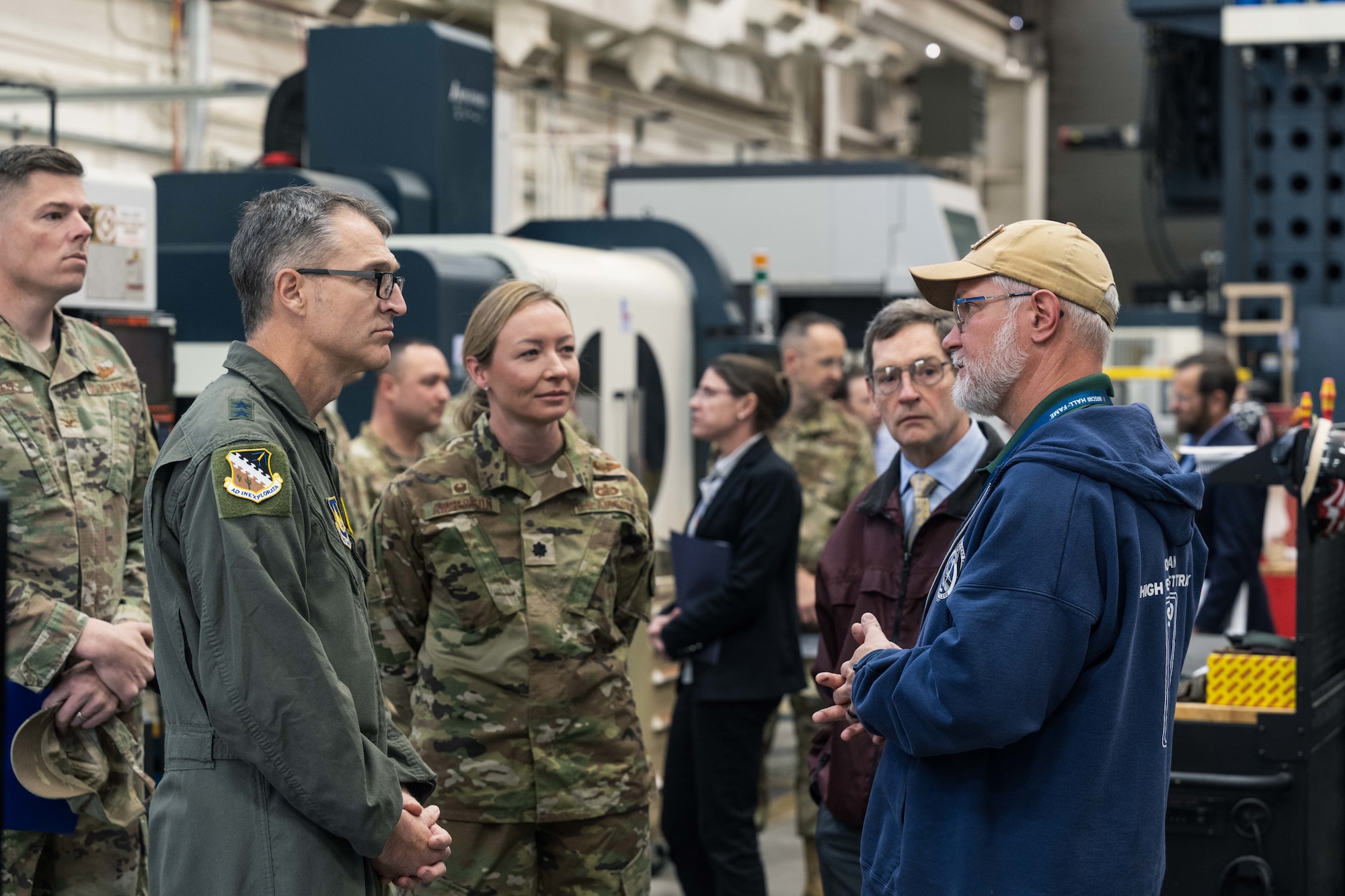 U.S. Air Force Maj. Gen. Scott Cain, Air Force Test Center commander, second left, hears about machining processes from Ziggy Pieszala, 846th Test Squadron model maker supervisor, at Holloman Air Force Base, New Mexico, March 21, 2025. Pieszala discussed various equipment used in daily work and suggestions for upgrades. (U.S. Air Force photo by Airman 1st Class Bob Teichmann)