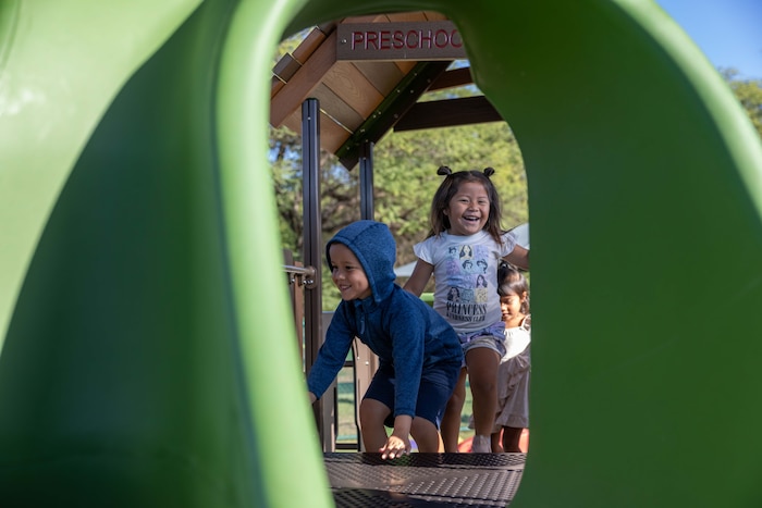 Preschoolers climb to the top as they explore their brand-new playground at the Pacific Missile Range Facility's (PMRF) Child Development Center (CDC).