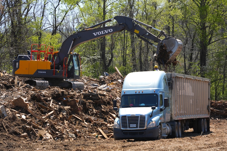 An excavator loads construction and demolition debris into a tractor-trailer at the Old Fort Debris Management Site in Old Fort, North Carolina, April 9, 2025. The site supports Hurricane Helene recovery by facilitating the proper sorting and removal of storm-related debris