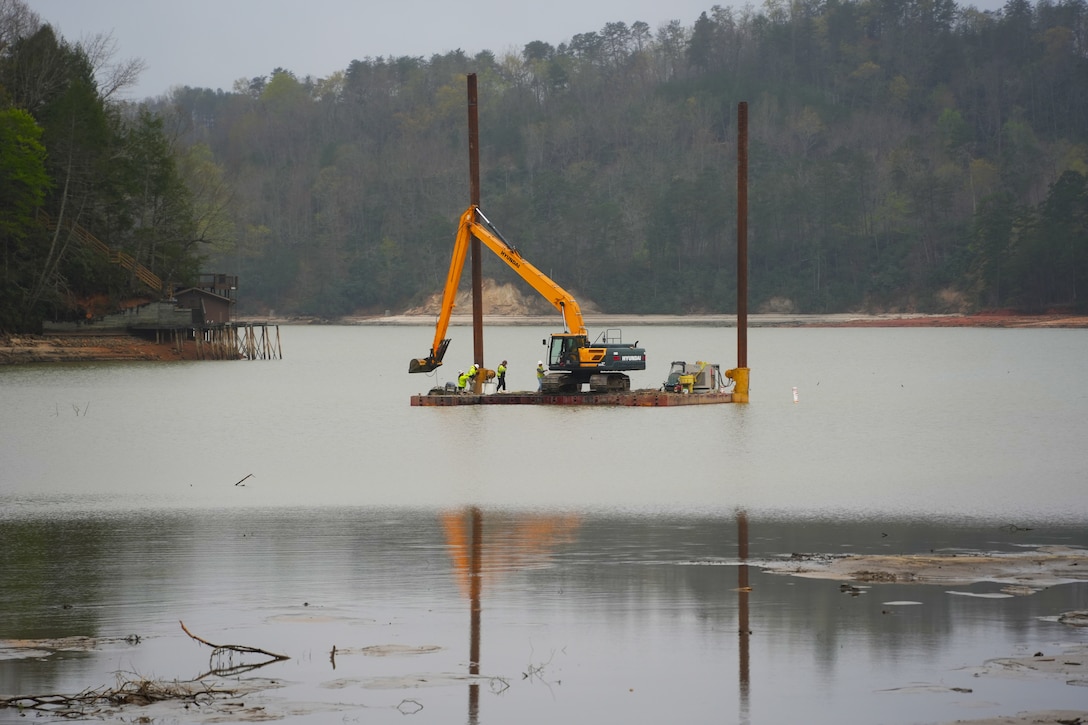 Contractors supporting the U.S. Army Corps of Engineers remove sediment from Lake Lure and the Broad River to restore navigability in support of Hurricane Helene recovery operations in Western North Carolina, April 2, 2025. Using heavy equipment such as excavators and rock trucks, crews are creating a passable waterway for barges to access and remove submerged debris. This sediment removal effort is a key step toward restoring safe conditions for the local community and facilitating long-term recovery.