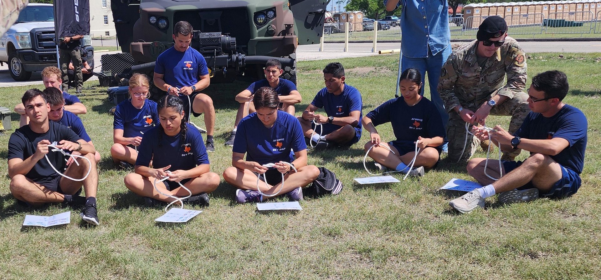 students sitting on ground with rope in front of them