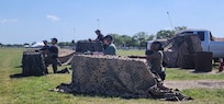servicemembers staging behind obstacles