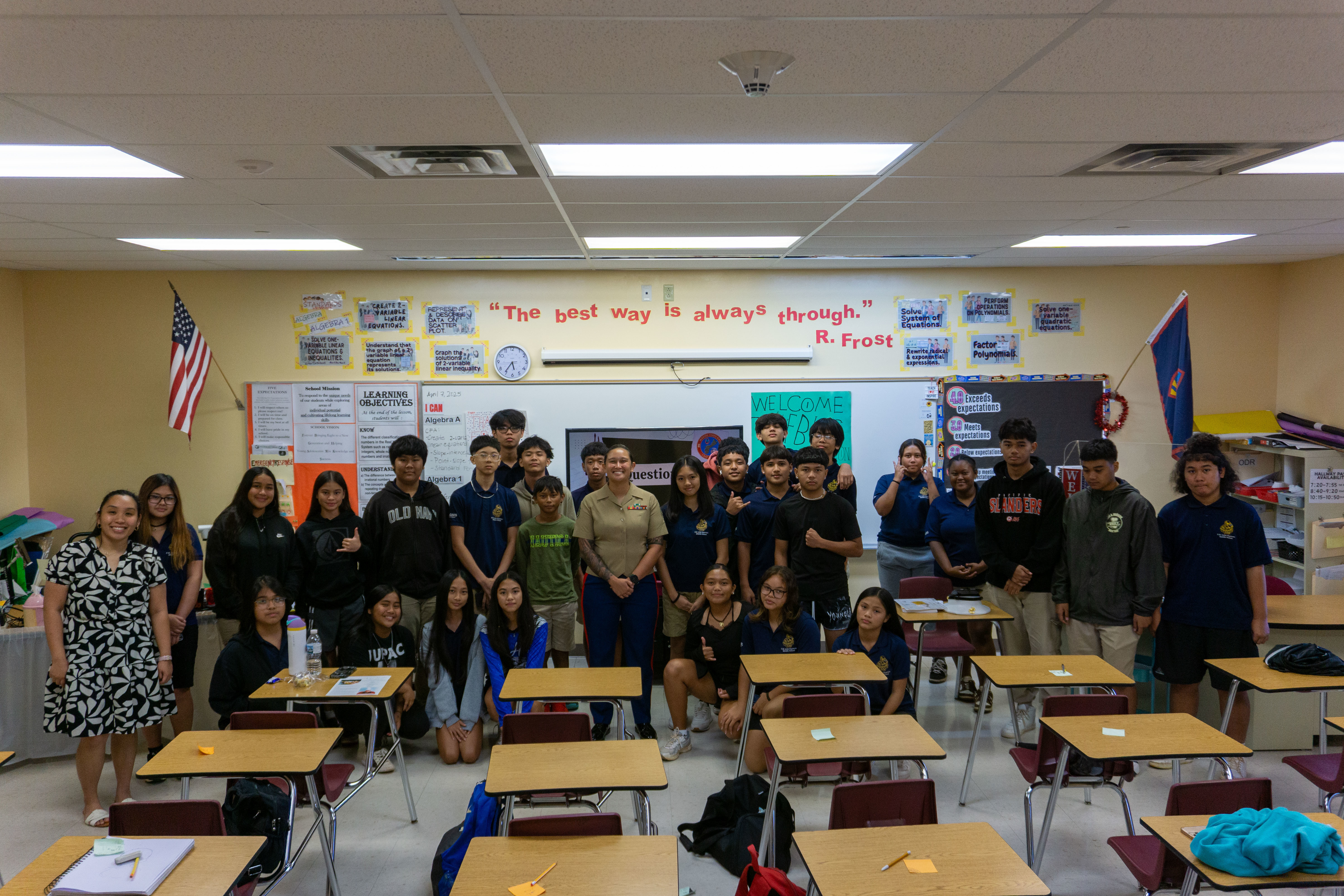 U.S. Marine Corps Staff Sgt. Jessica Suarez-Pierce, manpower chief, Marine Corps Base Camp Blaz, poses with a F.B. Leon Guerrero Middle School class after a career day presentation at Okkodo High School, Dededo, Guam, April 4, 2025. Staff Sgt. Suarez-Pierce explained the different career paths possible throughout the Marine Corps in a classroom presentation setting. (U.S. Marine Corps photo by Chelsey Suarez-Pierce)