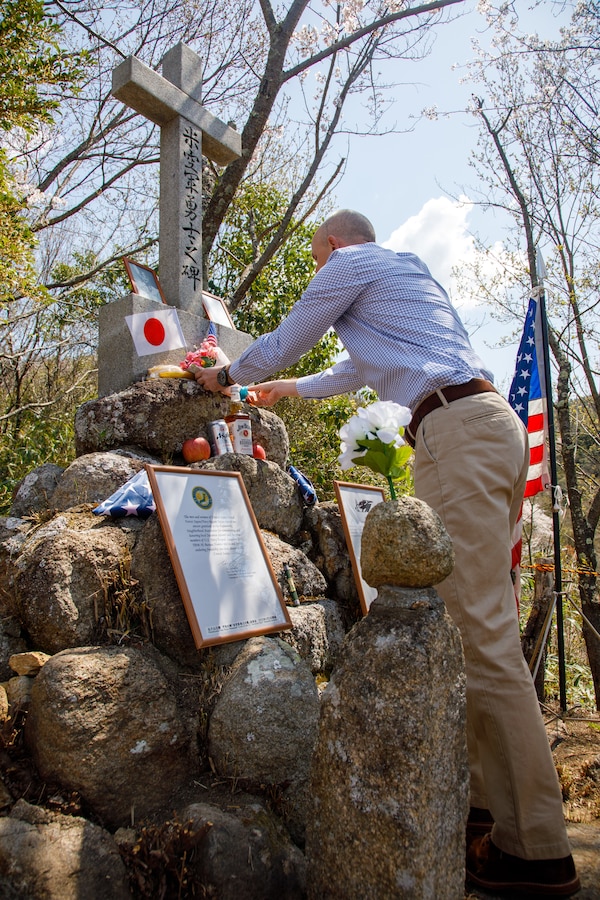 U.S. Marine Corps Maj. Matthew Forshee, the executive officer of Headquarters and Headquarters Squadron, Marine Corps Air Station Iwakuni and a native of Texas, places flowers on a monument to fallen Americans during the 80th anniversary of the Marukoyama Memorial Ceremony in Kure City, Hiroshima Prefecture, Japan, April. 3, 2025. The Marukoyama Memorial Ceremony is held every year in Kure during cherry blossom season to honor the crew members of the U.S. Navy TBM-3 Avenger, Torpedo Squadron 6, who died in Kure City, Hiroshima Prefecture, Japan, on July 24, 1945. (U.S. Marine Corps photo by Sgt. Randall Whiteman)