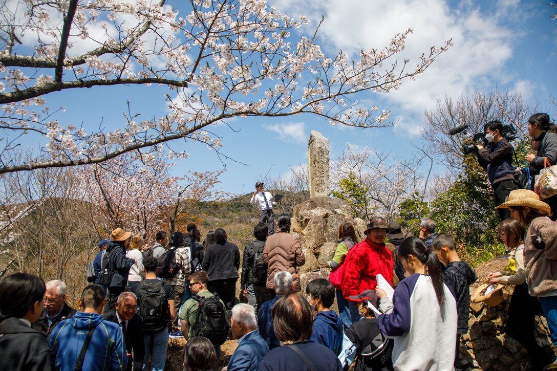 Fukao Hiroyuki, the U.S. participation coordinator for the Marukoyama Memorial Ceremony, explains the inscription on the Furukawa family memorial to the U.S. Marines and Sailors from Marine Corps Air Station Iwakuni after the 80th anniversary of the Marukoyama Memorial Ceremony in Kure City, Hiroshima Prefecture, Japan, April. 3, 2025. The Marukoyama Memorial Ceremony is held every year in Kure during cherry blossom season to honor the crew members of the U.S. Navy TBM-3 Avenger, Torpedo Squadron 6, who died in Kure City, Hiroshima Prefecture, Japan, on July 24, 1945. (U.S. Marine Corps photo by Sgt. Randall Whiteman)