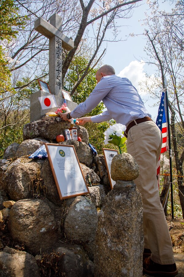 U.S. Marine Corps Maj. Matthew Forshee, the executive officer of Headquarters and Headquarters Squadron, Marine Corps Air Station Iwakuni and a native of Texas, places flowers on a monument to fallen Americans during the 80th anniversary of the Marukoyama Memorial Ceremony in Kure City, Hiroshima Prefecture, Japan, April. 3, 2025. The Marukoyama Memorial Ceremony is held every year in Kure during cherry blossom season to honor the crew members of the U.S. Navy TBM-3 Avenger, Torpedo Squadron 6, who died in Kure City, Hiroshima Prefecture, Japan, on July 24, 1945. (U.S. Marine Corps photo by Sgt. Randall Whiteman)