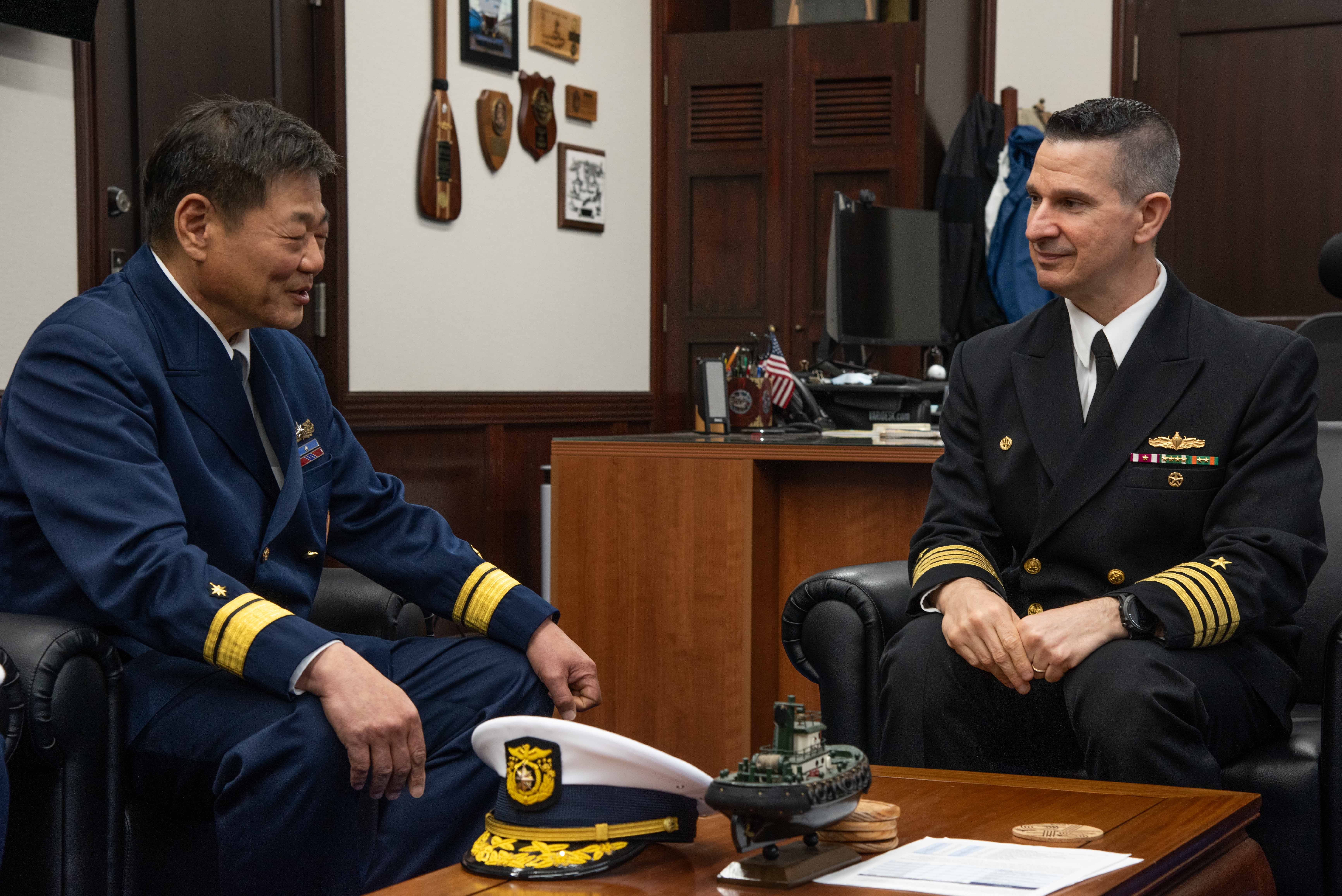 Capt. Les Sobol, Commander, Fleet Activities Yokosuka (CFAY), speaks with Rear Adm. Osamu Etani, chief of the Yokosuka Coast Guard Office and captain of the Port, Yokosuka, during an office call.