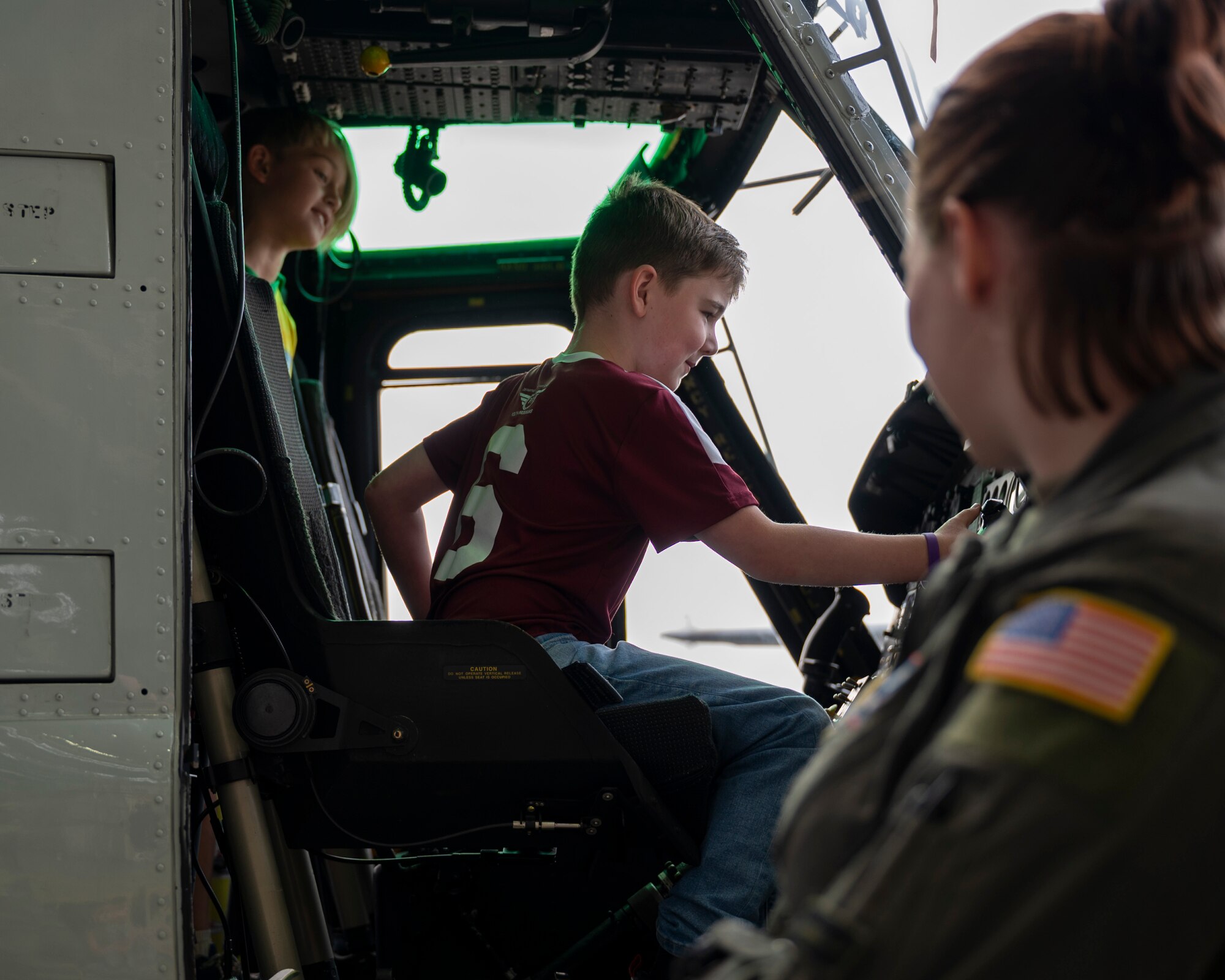 A child sits in the front seat of a helicopter.