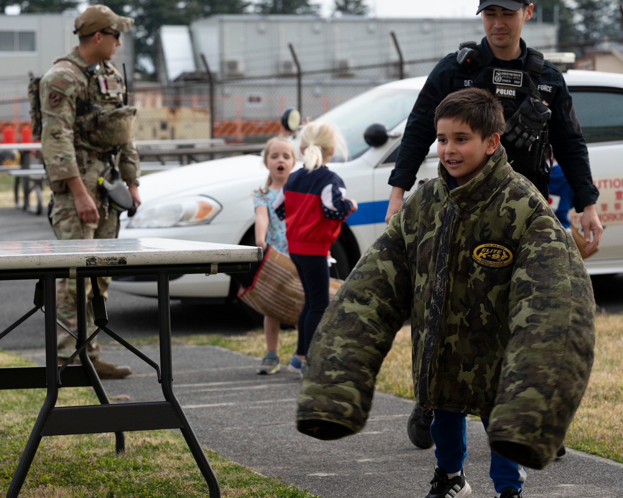 A child tries on a large K-9 jacket.