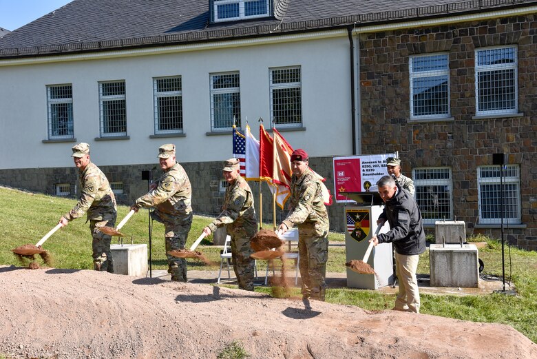 line of people holding shovels