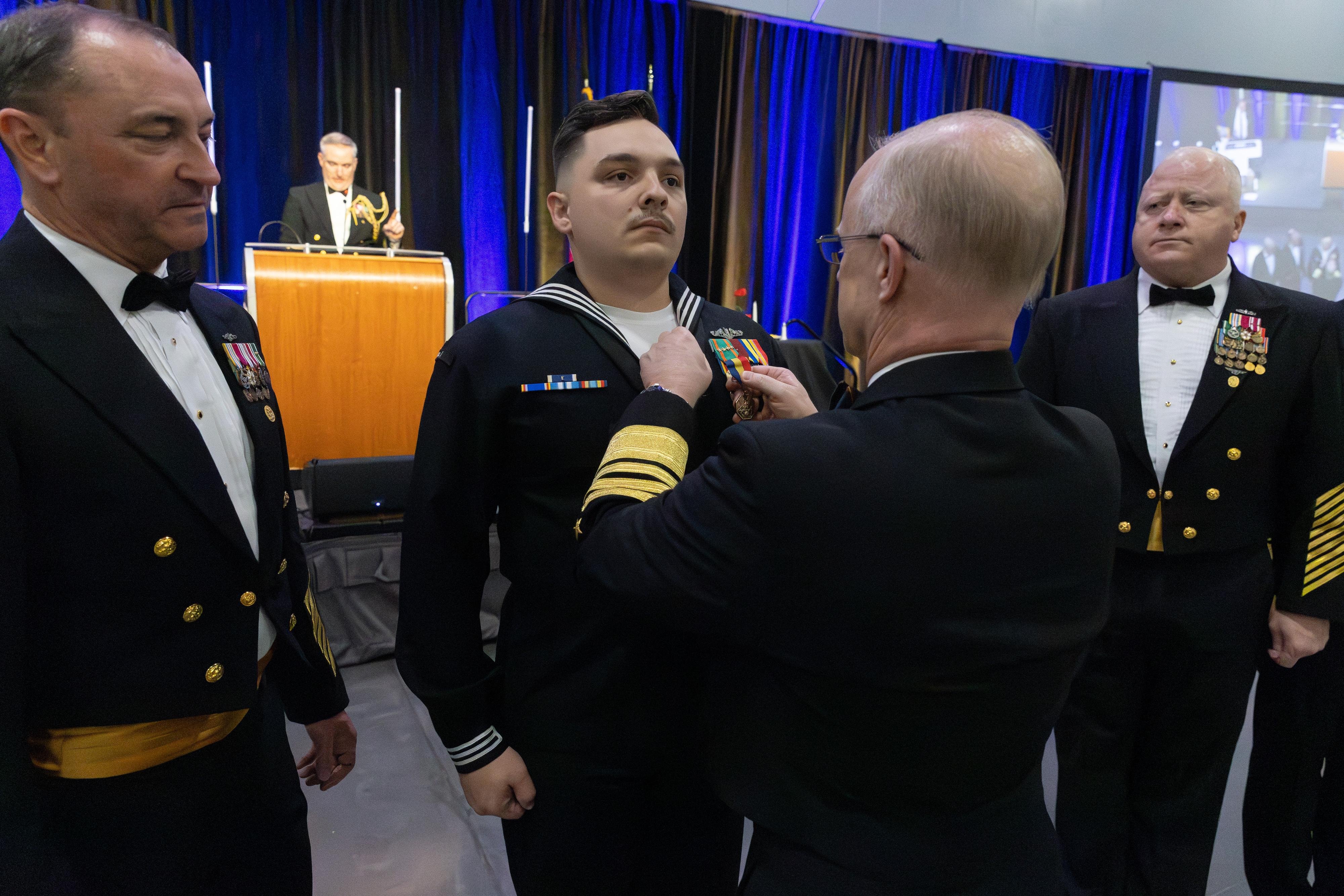 Adm. Caudle presents the Navy and Marine Corps Medal to ETN1 Journey