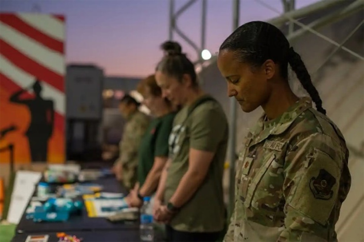 Airman bows her head during service.
