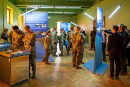U.S. service members and other attendees explore the new exhibit titled “Message Follows” following its opening at the Latvian War Museum in Riga, Latvia, April 11, 2025.